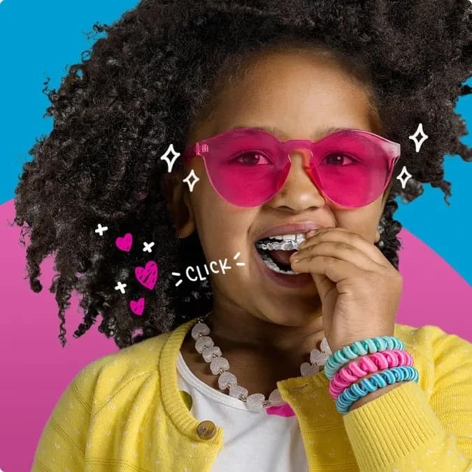 Una bambina con gli occhiali rosa indossa gli aligner Invisalign®