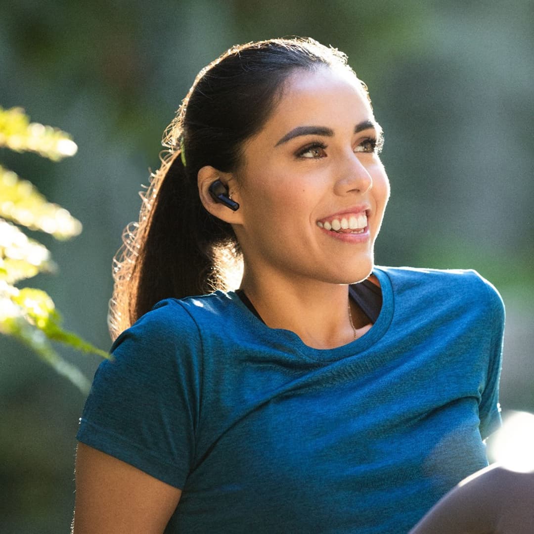 Ragazza che fa ginnastica all'aperto e sorride dopo il trattamento Invisalign®