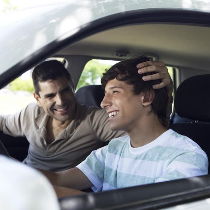 Padre e figlio sorridono in auto dopo il trattamento Invisalign®