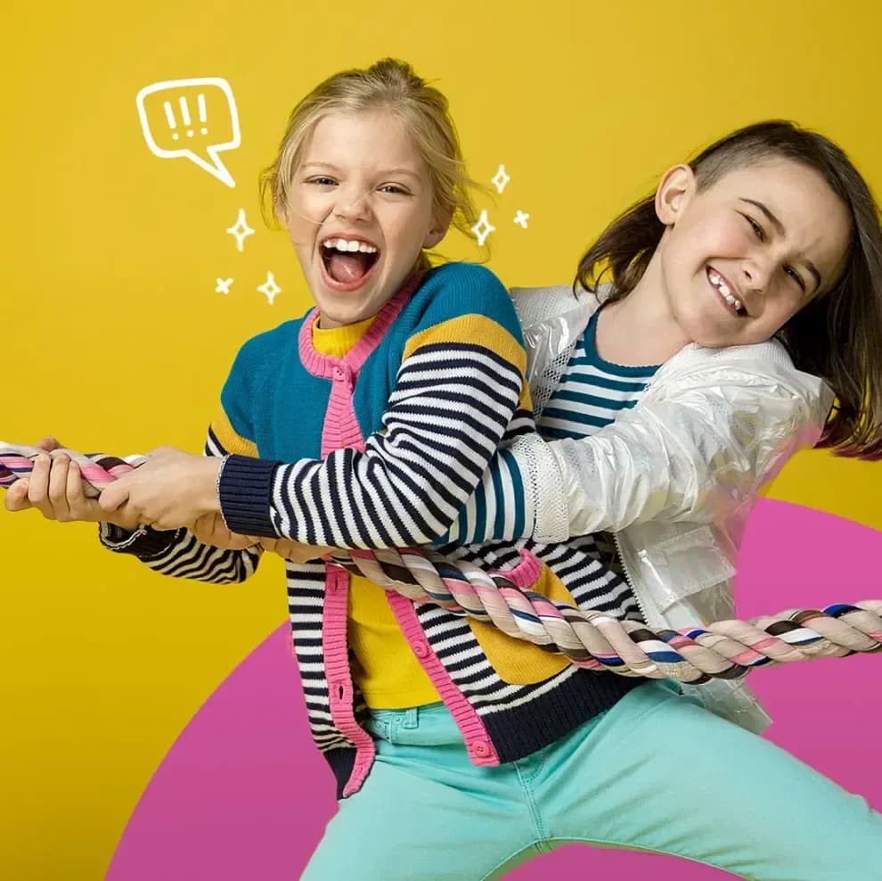 Ragazze che giocano al tiro alla fune e sorridono