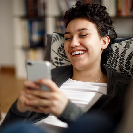 Ragazza che sorride al telefono dopo il trattamento Invisalign®